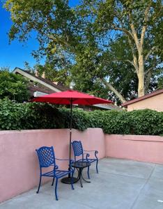 two chairs and a red umbrella next to a wall at Downtown Private Master Suite in Sacramento