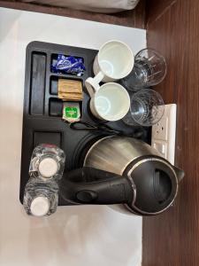 a coffee pot and cups are in a box at S K Tower Hotels in Nawāda