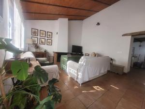 a living room with white chairs and a table at El Corral de la Higuera in Campofrío