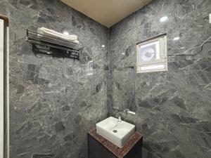 a black marble bathroom with a sink and a window at S K Tower Hotels in Nawāda +23 photos