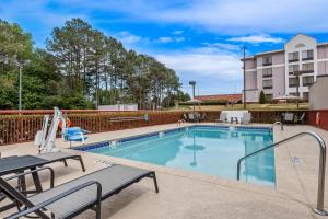 a swimming pool with a table and chairs and a building at Hampton Inn Carrollton in Carrollton