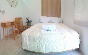 a white bed with a tray on top of it at 365house in Ban Phlu Yai
