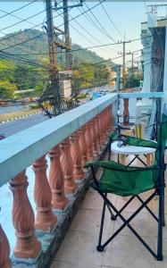 a green chair sitting on a balcony with a table at 365house in Ban Phlu Yai