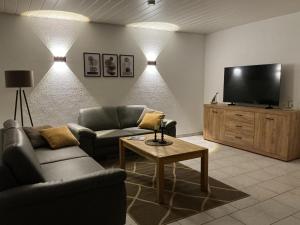 a living room with two couches and a flat screen tv at Große Auszeit in Gammendorf
