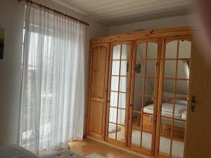 a bedroom with a wooden cabinet and a window at Große Auszeit in Gammendorf +3 photos