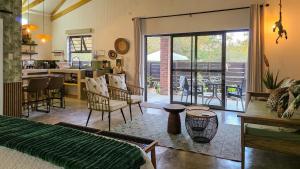 a living room with a bed and a kitchen with a patio at Khaya Kwalata in Marloth Park