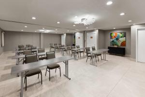 a waiting room with tables and chairs and a painting at La Quinta by Wyndham Laredo Airport in Laredo +47 photos