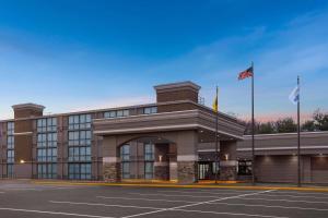 a building with two flags in a parking lot at Days Hotel by Wyndham Toms River Jersey Shore in Toms River