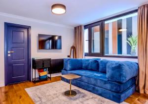 a blue couch in a living room with a window at Zorba&Bond Boutique Hotel in Tbilisi City +58 photos