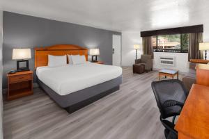 a hotel room with a bed and a living room at Baymont by Wyndham Durango in Durango +30 photos
