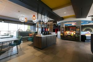 a restaurant with a bar and tables and chairs at Tru By Hilton Hazleton in Hazleton