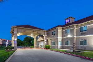 a large building with an arch in a driveway at Baymont by Wyndham Texas City in Texas City