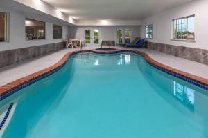 a swimming pool with blue water in a house at Baymont by Wyndham Texas City in Texas City