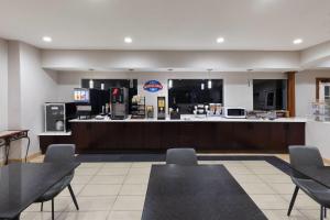 a restaurant with tables and chairs and a counter at Baymont by Wyndham Texas City in Texas City