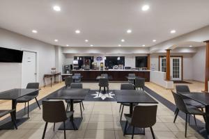 a restaurant with tables and chairs and a bar at Baymont by Wyndham Texas City in Texas City