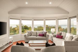 a living room with couches and a tv and windows at Seaview Escape in Ventnor