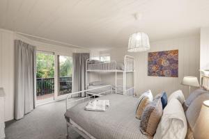 a white bedroom with a bed and a balcony at Seaview Escape in Ventnor
