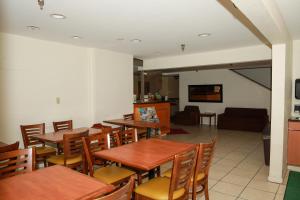 a restaurant with tables and chairs and a living room at Townhouse Super Gallup - I-40 in Gallup