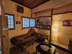 ein Wohnzimmer mit Sofa und Tisch in der Unterkunft Hostel Caranashi Osaka Imazato in Osaka