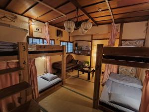 ein Zimmer mit zwei Etagenbetten und einer Couch in der Unterkunft Hostel Caranashi Osaka Imazato in Osaka