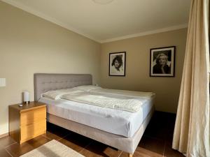 a bed in a bedroom with two pictures on the wall at Casa Sole in Gambarogno