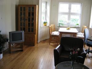 sala de estar con TV, silla y mesa en Ferienwohnung Gutzeit, en Flensburg