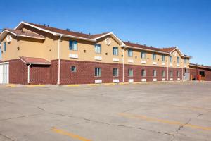a large red brick building with a parking lot at Townhouse Super Gallup - I-40 in Gallup