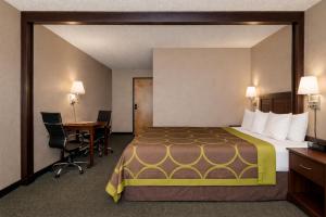 a hotel room with a large bed and a desk at Townhouse Super Gallup - I-40 in Gallup +21 photos