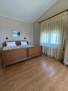 a bedroom with a large bed and a large window at Palio Dream House in Paleo Tsifliki