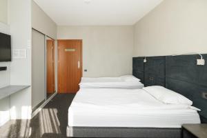 a bedroom with two beds and a television in it at Jūratės B&B Namai in Karmėlava