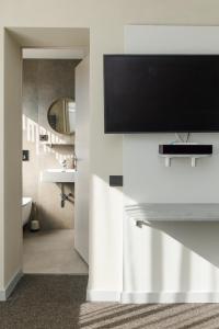 a bathroom with a tv on a wall at Jūratės B&B Namai in Karmėlava