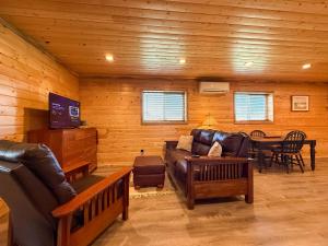 a living room with a leather couch and a table at Cozy Pine Getaway in Sequim +10 photos