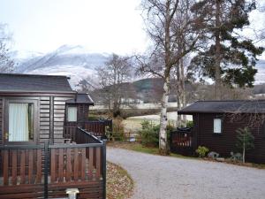 a cabin with a fence next to a house at Burnside Park in Keswick