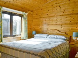a bedroom with a bed in a log cabin at Burnside Park in Keswick +5 photos
