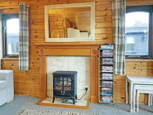 a fireplace in a wooden room with a stove at Burnside Park in Keswick