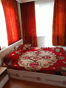 a bed in a room with red curtains and a window at Pretty house in Panagyurishte