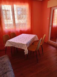 a dining room with a table and chairs and a window at Pretty house in Panagyurishte