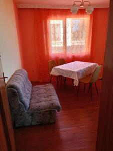 a living room with a table and a couch and a window at Pretty house in Panagyurishte