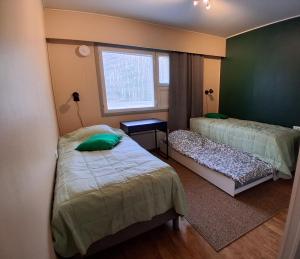 a bedroom with two beds and a window at Hostelli Havumaja in Puumala