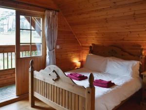 a bedroom with a bed in a log cabin at Sun Rise Lodge No 10 - Hw7655 in Llanbedr +10 photos