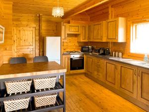 a kitchen with wooden cabinets and a white refrigerator at Sun Rise Lodge No 10 - Hw7655 in Llanbedr