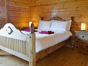 a bedroom with a bed in a log cabin at Sun Rise Lodge No 10 - Hw7655 in Llanbedr