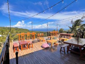 a deck with wooden tables and chairs and a view of the ocean at Taylors Plantacion Resort- Grande Ground Floor in Tangaro