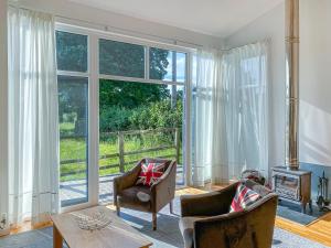 a living room with a large window and chairs and a table at Yew Tree Barn - Hw7737 in Usk