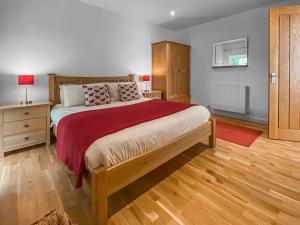a bedroom with a large bed and a wooden floor at Yew Tree Barn - Hw7737 in Usk +4 photos