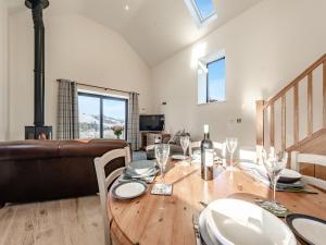 a dining room with a table and a couch at Parlwr Godro - Uk41513 in Llanfair Clydogau