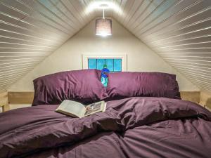 a bedroom with a purple bed with a book on it at Jacobs Folly-Qu7115 in Melton Constable +19 photos