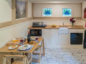 a kitchen with a wooden table and a sink at Jacobs Folly-Qu7115 in Melton Constable