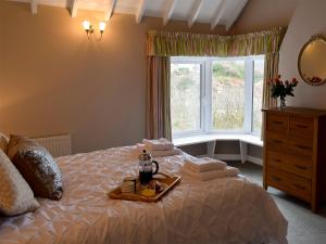 a bedroom with a bed with a tray of towels and a window at Puzzle Corner in Sandsend
