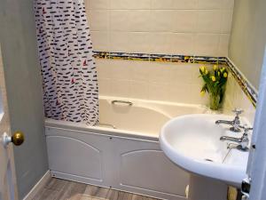 a bathroom with a sink and a bath tub with a sink at Puzzle Corner in Sandsend +4 photos